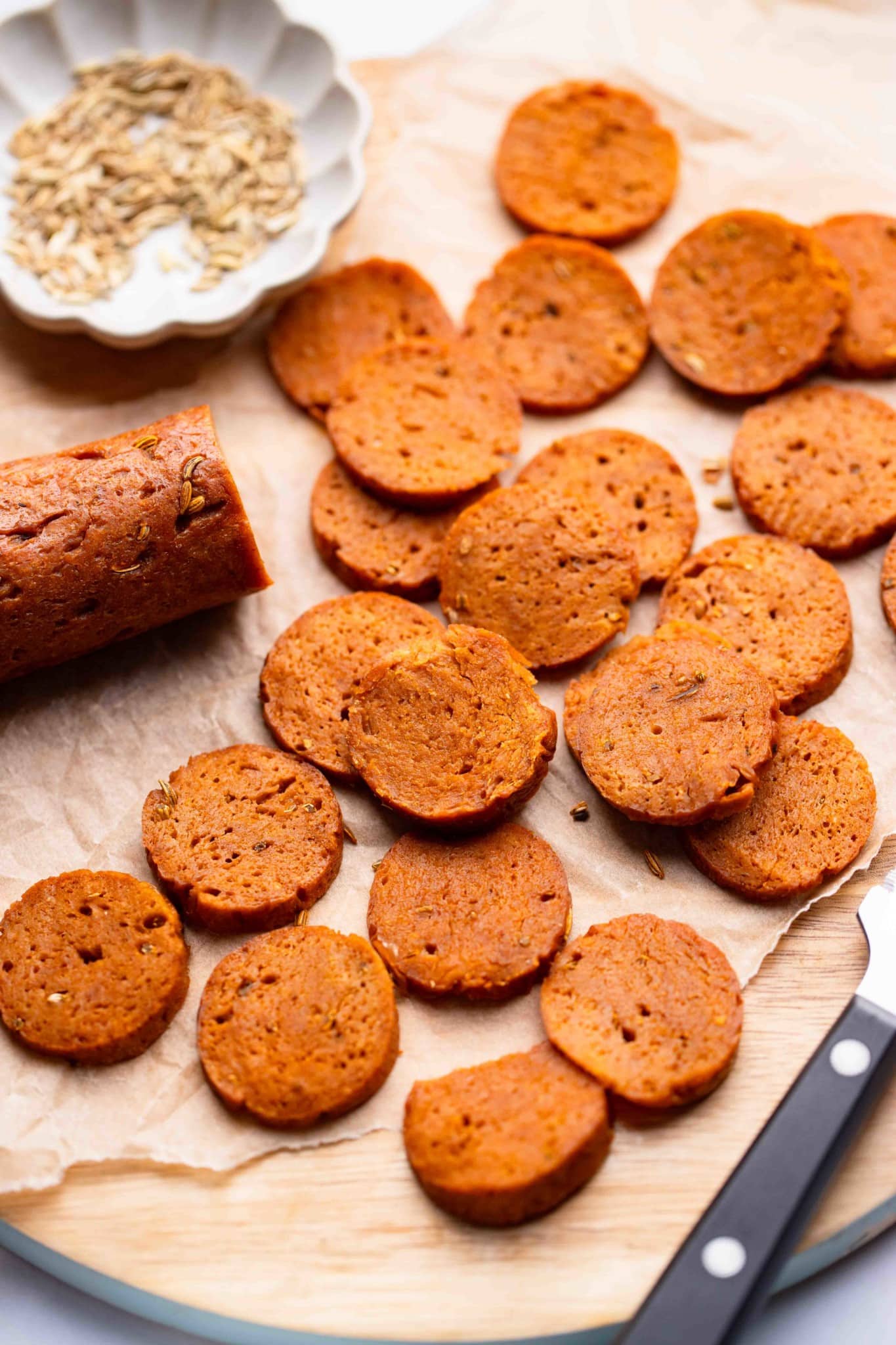 sliced vegan pepperoni on a wood board.