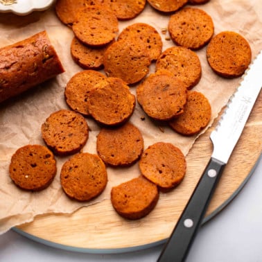 sliced vegan pepperoni on a wood board.