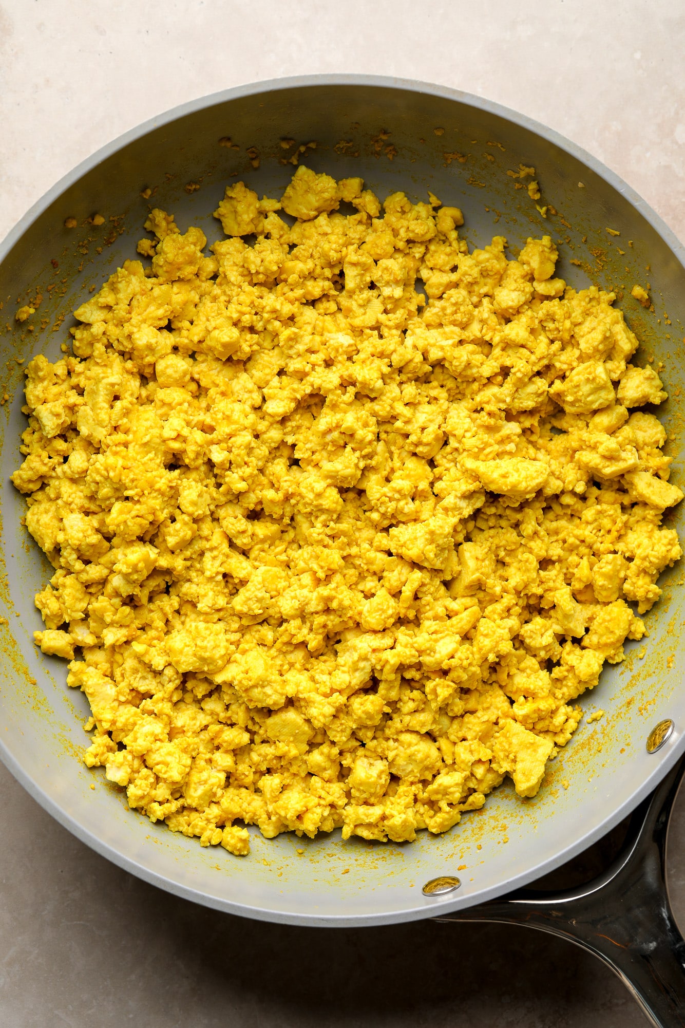 yellow tofu scramble cooking in a skillet.