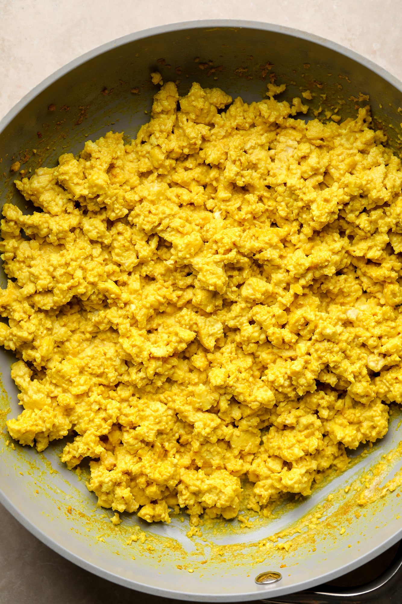 yellow tofu scramble cooking in a skillet.