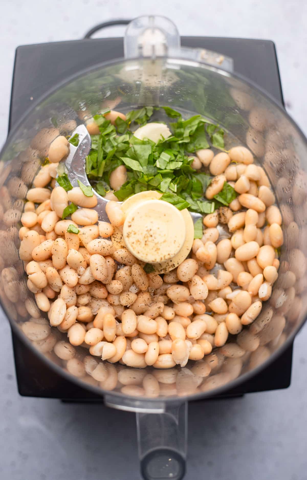 ingredients for white bean dip in a food processor.