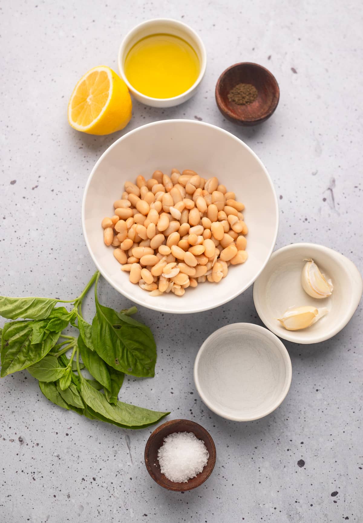 ingredients for white bean dip in individual white bowls.