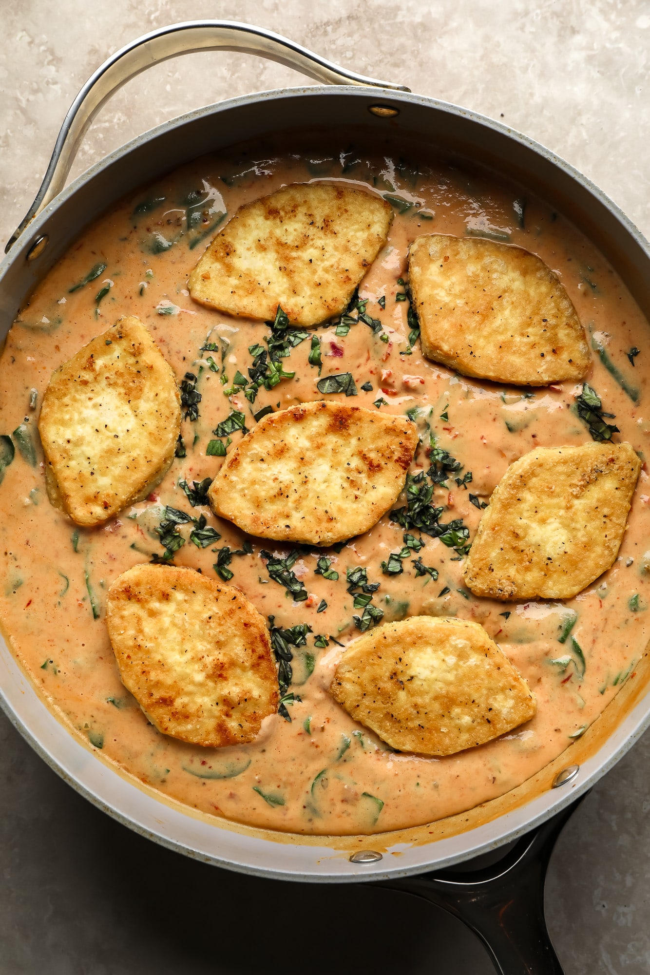 fried tofu pieces in marry me tofu sauce in a skillet.